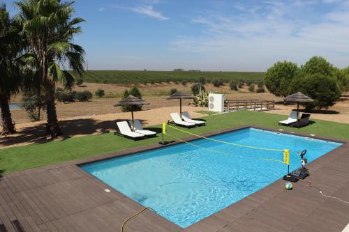 a large swimming pool with chairs and anophe at Monte da Figueira Brava in Aldeia dos Ruins