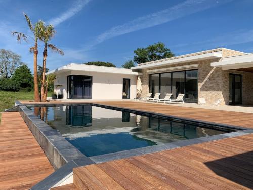una piscina davanti a una casa di Luxurious Architect-Designed Villa with Pool a Belin-Beliet
