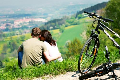 a man and woman sitting on a hill with a bike at Villa Campana in Siófok