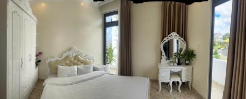 ein Schlafzimmer mit einem weißen Bett und einem Spiegel in der Unterkunft Khách Sạn in Xuan An