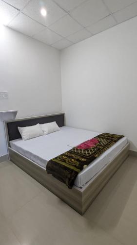 una camera bianca con un letto in una stanza di Assam Inn Lodge & Restaurant a Guwahati