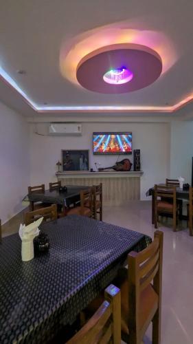 una sala da pranzo con tavolo, sedie e soffitto viola di Assam Inn Lodge & Restaurant a Guwahati