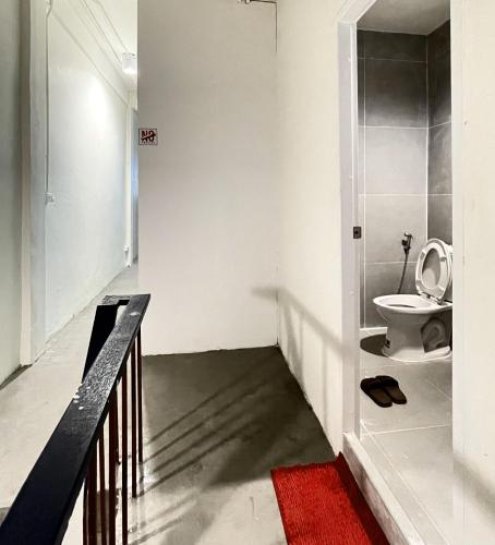 a bathroom with a toilet and a red rug at Moon Pīti in Bangkok