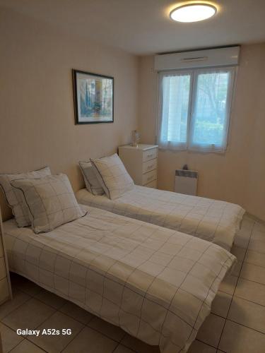 deux lits côte à côte dans une chambre dans l'établissement Charmant T2 au calme proche de la mer, à La Seyne-sur-Mer