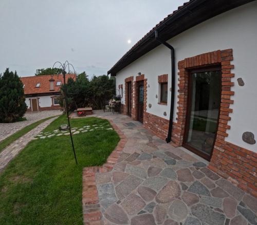 a courtyard of a house with a brick building at Miejski Las 8 in Mrągowo