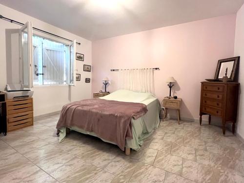 une chambre avec un lit, une commode et une fenêtre dans l'établissement Villa Pescalune, à Lunel