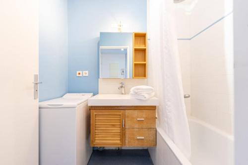 une salle de bain avec un lavabo, un miroir et une baignoire dans l'établissement Le Lagon Bleu - Appartement La Rochelle, à La Rochelle