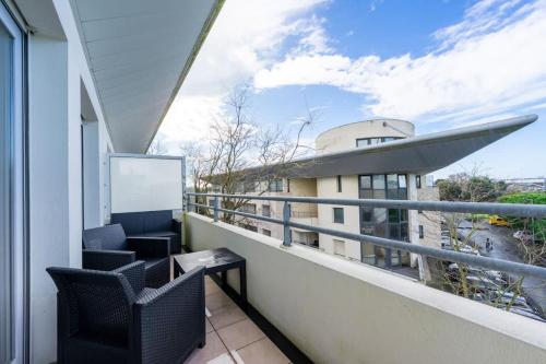- un balcon avec deux chaises et une table dans l'établissement Le Lagon Bleu - Appartement La Rochelle, à La Rochelle