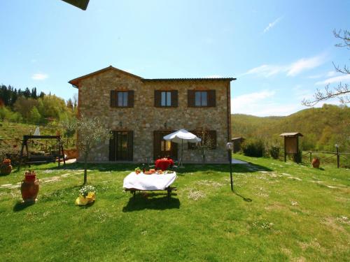 duży kamienny dom ze stołem przed nim w obiekcie Stunning Farmhouse in Passignano with Pool w mieście Passignano sul Trasimeno