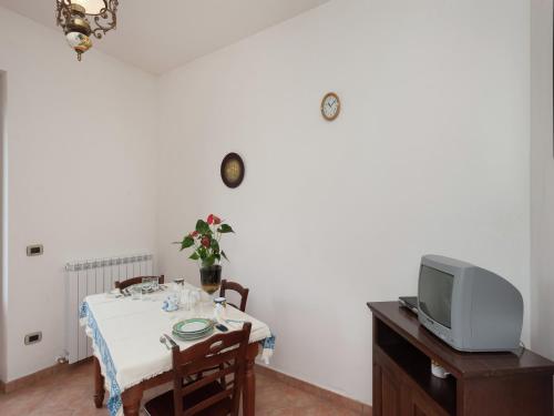 a dining room with a table and a tv at Stunning Farmhouse in Passignano with Pool in Passignano sul Trasimeno