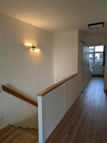 an empty room with a hallway with a stairway at TOP KaVi apartments #7, Pool, Sauna und Fitness FREE, 2-Zimmer in Sankt Englmar