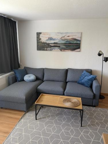 a living room with a blue couch and a coffee table at TOP KaVi apartments #7, Pool, Sauna und Fitness FREE, 2-Zimmer in Sankt Englmar