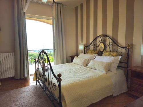 a bedroom with a bed with white sheets and a window at Villa Cristina in Boissano
