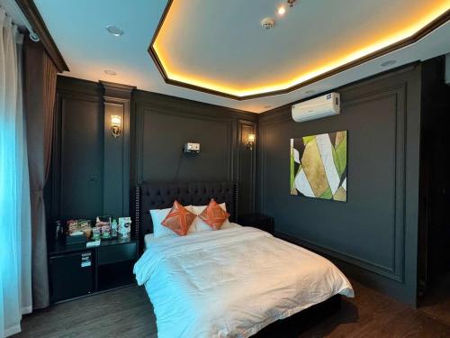 FLC Sea Tower Quy Nhơn-Khách Sạn Mặt Biển-Hồ Bơi Vô Cực-Thanh Apartment في كوي نون: غرفة نوم مع سرير ووسائد برتقالية عليه