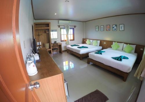 a hotel room with two beds and a kitchen at Medio De Pai in Pai