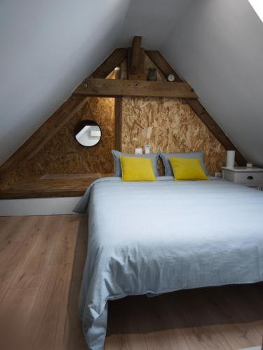 une chambre avec un grand lit avec des oreillers jaunes dans l'établissement Campagne étoilée, à Bellacaud