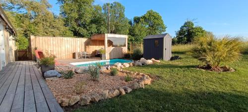une cour arrière avec une petite piscine et un cabanon dans l'établissement Campagne étoilée, à Bellacaud