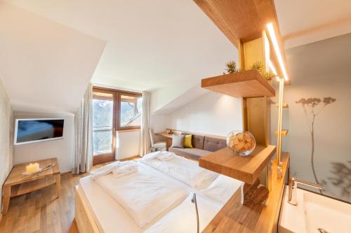 a small bedroom with a bed and a couch at Herol - my mountain retreat in Luson