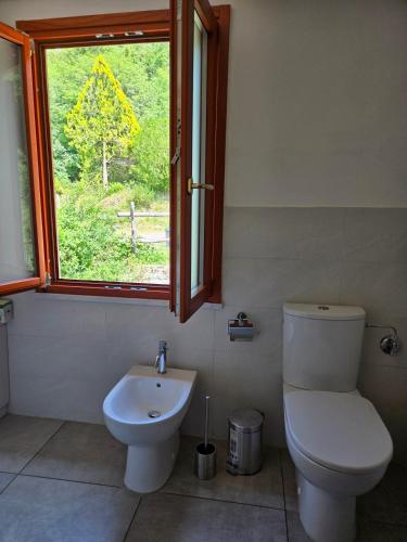 a bathroom with a toilet and a sink and a window at Sole di Bagnone in Bagnone