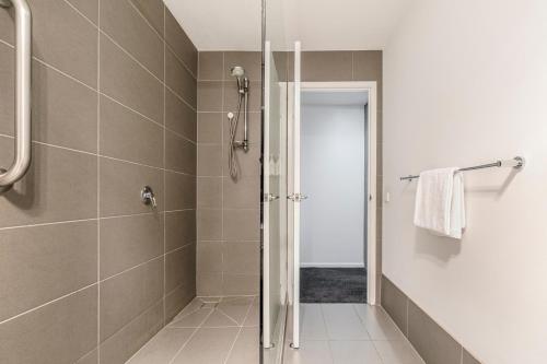 a shower with a glass door in a bathroom at Punthill Apartment Hotel - Manhattan in Melbourne