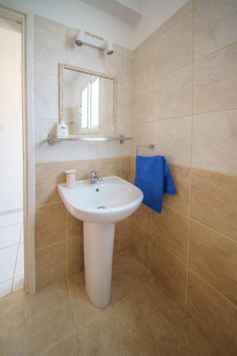 a bathroom with a white sink and a mirror at Seaside Villa Luci with jacuzzi and just minutes away from Ayia Triada beach in Paralimni