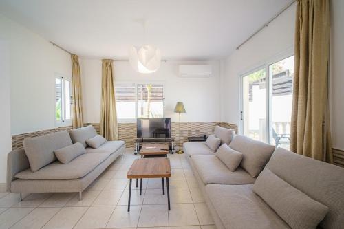 a living room with two couches and a table at Seaside Villa Luci with jacuzzi and just minutes away from Ayia Triada beach in Paralimni