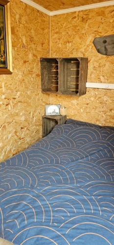 a bedroom with a bed in a wooden wall at Flips et mousse in Gembloux