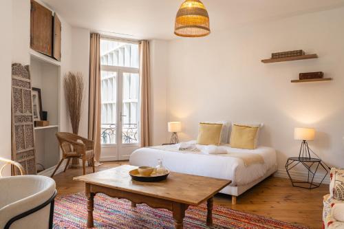 - une chambre avec un lit et une table basse dans l'établissement Appartements en Centre Ville de Bordeaux, à Bordeaux