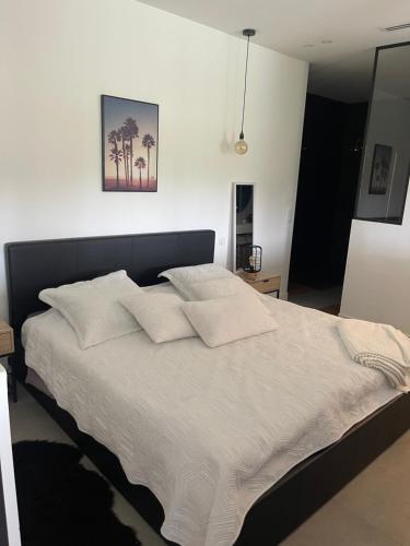 un lit avec des draps blancs et des oreillers dans une chambre dans l'établissement Apparemment luxueux, à Biot