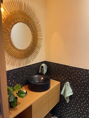 une salle de bain avec un lavabo noir et un miroir dans l'établissement Apparemment luxueux, à Biot