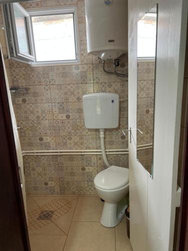 a small bathroom with a toilet and a window at Etno kuća Danica in Senje