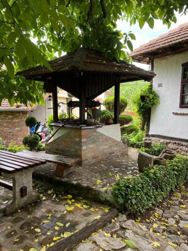 a pavilion with a table and a bench in a yard at Etno kuća Danica in Senje
