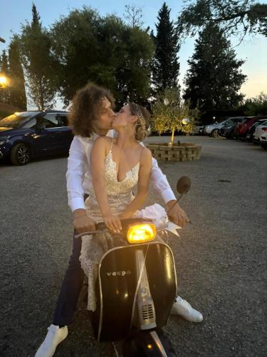 a bride and groom kissing on a scooter at Terracqua & Locanda Granducato in Chiusi