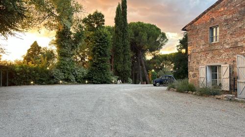 a driveway with a car parked next to a building at Terracqua & Locanda Granducato in Chiusi