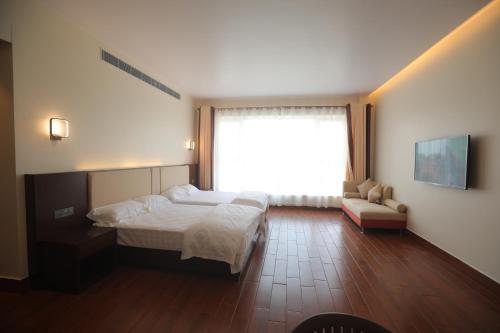 a bedroom with a bed and a large window at Nalluri Garden Resort in Kottapatnam