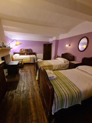 ein Hotelzimmer mit zwei Betten und lila Wänden in der Unterkunft Hotel des Etrangers in Saint-Martin-dʼEntraunes