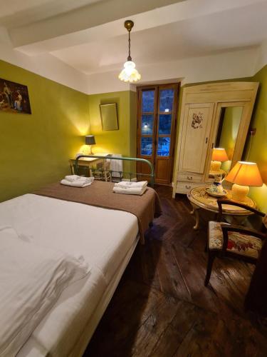 une chambre d'hôtel avec deux lits et une table dans l'établissement Hotel des Etrangers, à Saint-Martin-dʼEntraunes