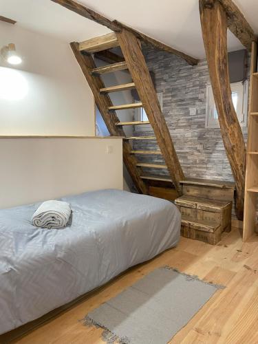 - une chambre avec un lit dans une pièce dotée de poutres apparentes dans l'établissement Maison de charme 4 personnes, à Montvalent