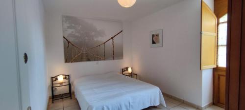 a bedroom with a bed and a bridge painting on the wall at La Grange de Rocamadour in Rocamadour