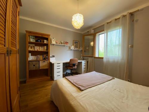 a bedroom with a bed and a desk and a window at Sous les chênes de Lavaur - détente et télétravail in Lavaur