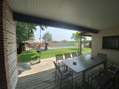 a patio with a table and chairs on a deck at Sous les chênes de Lavaur - détente et télétravail in Lavaur