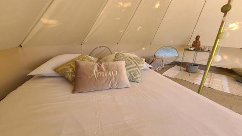 a bed in a tent with pillows on it at Nuit insolite tente l'âme agit proche Mont Saint Michel in Le Ferré