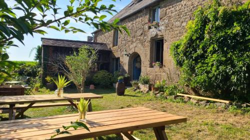 - une table de pique-nique devant un bâtiment en pierre dans l'établissement Nuit insolite tente l'âme agit proche Mont Saint Michel, à Le Ferré