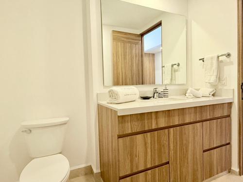 a bathroom with a toilet and a sink with a mirror at Beachfront family friendly 1 bdr NT505 in Puerto Vallarta
