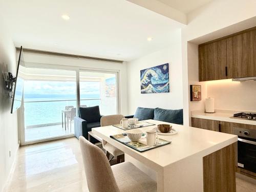 a kitchen and living room with a table and a dining room at Beachfront family friendly 1 bdr NT505 in Puerto Vallarta
