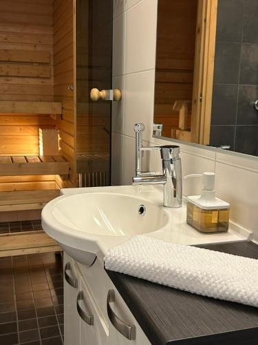 a bathroom with a white sink and a tub at One bedroom apartment in Rovaniemi