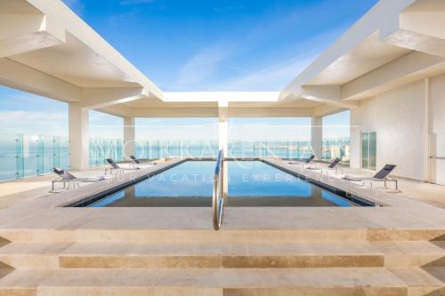 a swimming pool in a building with chairs at Beachfront family friendly 1 bdr NT505 in Puerto Vallarta