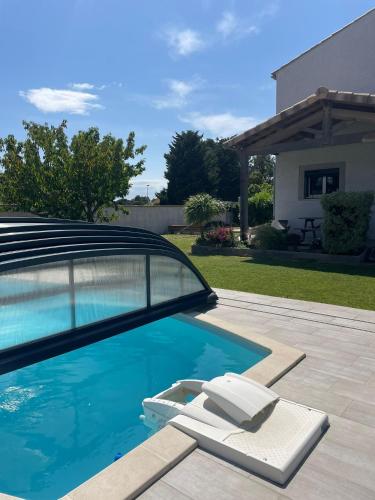 - une piscine avec 2 chaises longues dans la cour dans l'établissement Villa Serenita, à Villemoustaussou