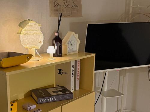 a book shelf with a tv and a bottle of wine at Stay Meomoolda in Seoul