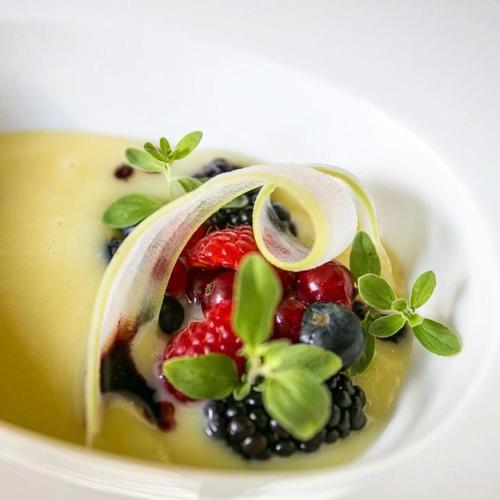 a bowl of food with berries and plants on it at Terracqua & Locanda Granducato in Chiusi